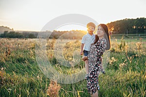 Stilish mother and handsome son having fun on the nature. Happy family concept. Beauty nature scene with family outdoor