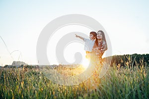 Stilish mother and handsome son having fun on the nature. Happy family concept. Beauty nature scene with family outdoor