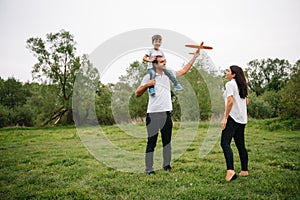 Stilish mother and handsome son having fun on the nature. Happy family concept. Beauty nature scene with family outdoor