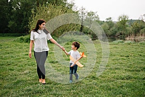 Stilish mother and handsome son having fun on the nature. Happy family concept. Beauty nature scene with family outdoor