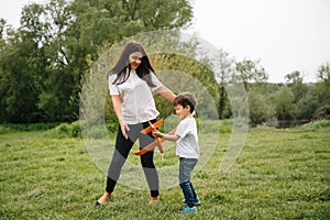 Stilish mother and handsome son having fun on the nature. Happy family concept. Beauty nature scene with family outdoor