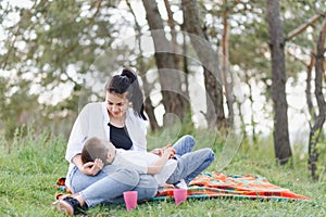 Stilish mother and handsome son having fun on the nature. Happy family concept. Beauty nature scene with family outdoor lifestyle