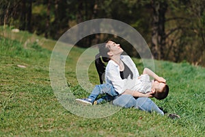 Stilish mother and handsome son having fun on the nature. Happy family concept. Beauty nature scene with family outdoor lifestyle