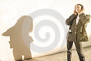 Stilish young teenage girl outside listen music near white wall