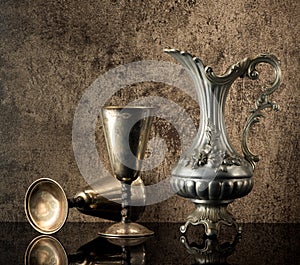 Still life with Ancient jug for wine and silver goblets