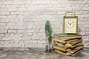 Still life of antique books with clock and pen with inkwell