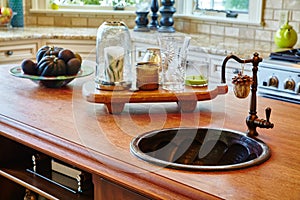 Still life of an antique kitchen with a wooden countertop, deep basin sink, and accoutrements