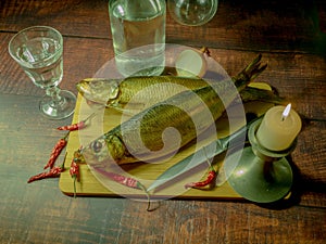 Still life in antique style with fish and alcohol .