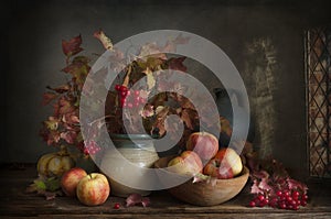 Still life with apples and scarlet viburnum autumn branches and berries in vintage style