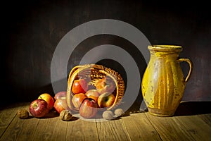 Still life with apples in a wicker basket on a table