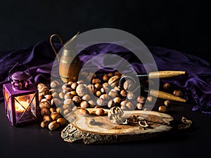 Still life arrangement with candlelight, spread peanuts, nuts, and lavender.