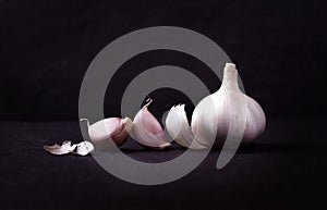 A still life arrangement of Three whole garlic bulbs grouped on