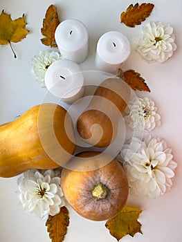 Still life with autumn leaves, white flowers, decorative pumpkin and candles