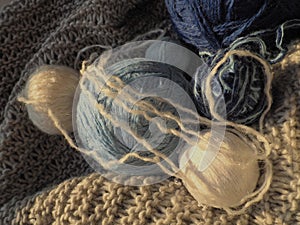 Still life of balls of yarn, woolen and acrylic threads, knitting needles, knitted products. Soft light from the window. Knitting