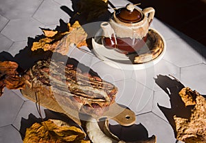 Still life Banana pie with a ceramic teapot in the rays of the autumn sun