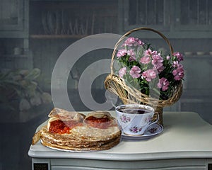 Still life with basket of carnation flowers and pancakes