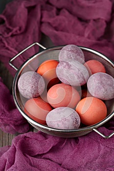 Still life of beautiful textured purple eggs in the sieve