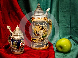 Still-life with beer mugs and a green apple.