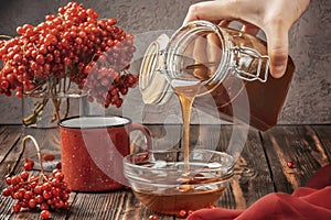 Still life berries of a viburnum in a glass and mug of hot tea and honey