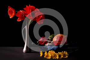 Still life on a black background. A bouquet of wild red poppies.