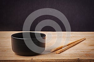 Still life black bowl with wooden shopsticks