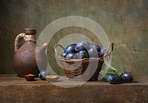 Still life with black plums in a basket photo