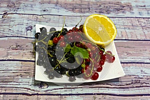 Still life black, red currant and half a lemon