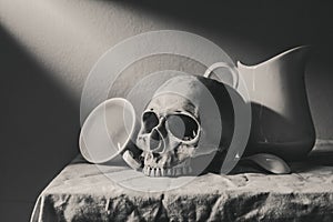 Still life black and white photography with human skull and cera