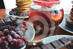 still life on blue plates pancakes with peas, grated chocolate, chocolate bars, brewed tea