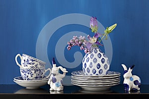 Still life with blue and white dishes and flowers in a little va