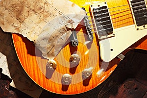 Still life with a blues vintage electric guitar and old sheet music closeup