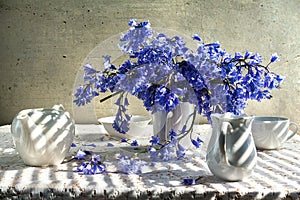 Still life bouquet blue tones white crockery