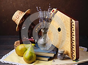 Still life with a bouquet of dried lavender in a transparent vase, dulcimer, books and two pears. Interior paintings, design photo