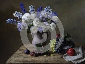 Still life with bouquet of garden flowers and forest fruits
