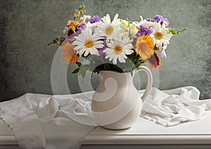 Still life with bouquet of summer flowers in a jar