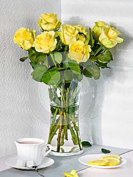 Still life with a bouquet of yellow roses and a Cup of tea