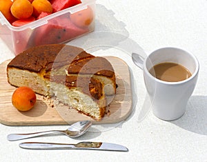 Still life with a bowl with apricots,  pie, coffee on a wooden table close-up.