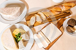 Still life: bread and cheeses served on the table, top view