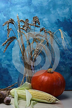 a still life with a bright blue background and seasonal harvest
