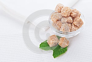 Still life with brown lump sugar, on white linen