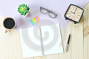 Top view or flat lay of open notebook paper with blank pages, accessories and coffee cup on wooden background, ready for adding or