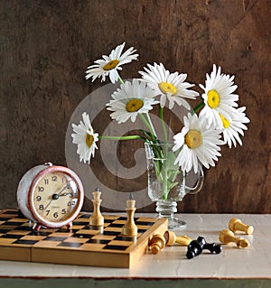 Still life with camomiles and chess