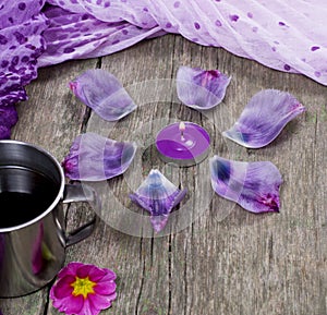 Still life, candle, petals and lilac scarf