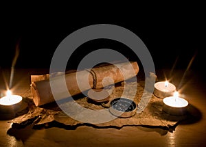 Still life with candles by a compass and old maps photo