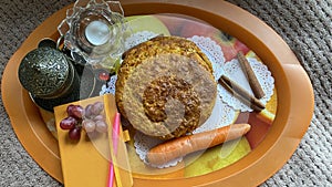 Still life of carrot cake, grapes, a cup of Turkish coffee, candles, cinnamon, notebook, and pens