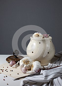 Still life with ceramic dishes with heads of garlic and pepper.