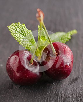 Still life with cherries in a copper mug also in a steel cup