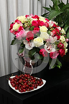 Still life of cherries and a gorgeous bouquet of roses