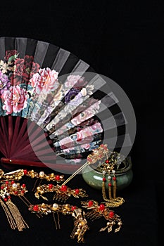 Still life in Chinese style. traditional hairpins, incense burner and fan isolated on black background