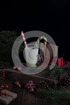 still life Christmas milk on a wooden table with Christmas decorations on a dark background